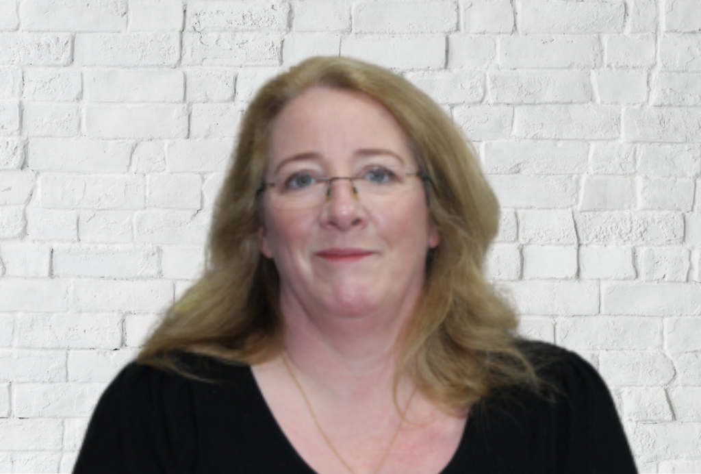 Woman smiling at the camera with glasses and long blonde hair.