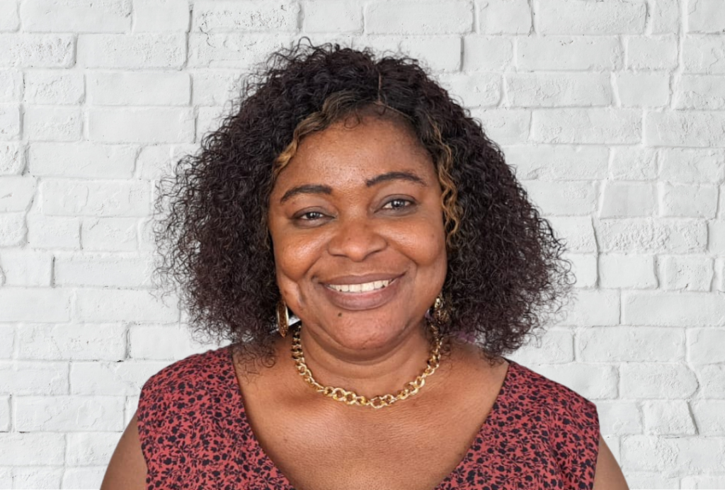 Woman smiles at the camera. She has shoulder length hair.