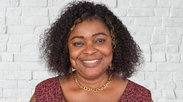 Woman smiles at the camera. She has shoulder length hair.