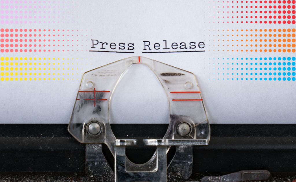 Typewriter with the words 'Press Release' typed. Coloured dots surround the text.