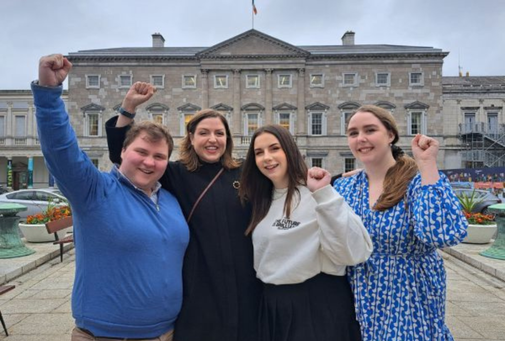 Members of our Youth Council and our CEO pose outside the Oireachtas with their fists raised in the air.