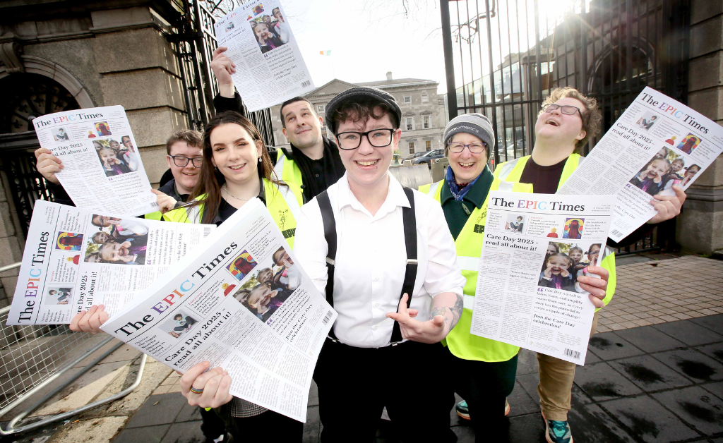 Group pose outside Leinster House holding copies of The EPIC Times